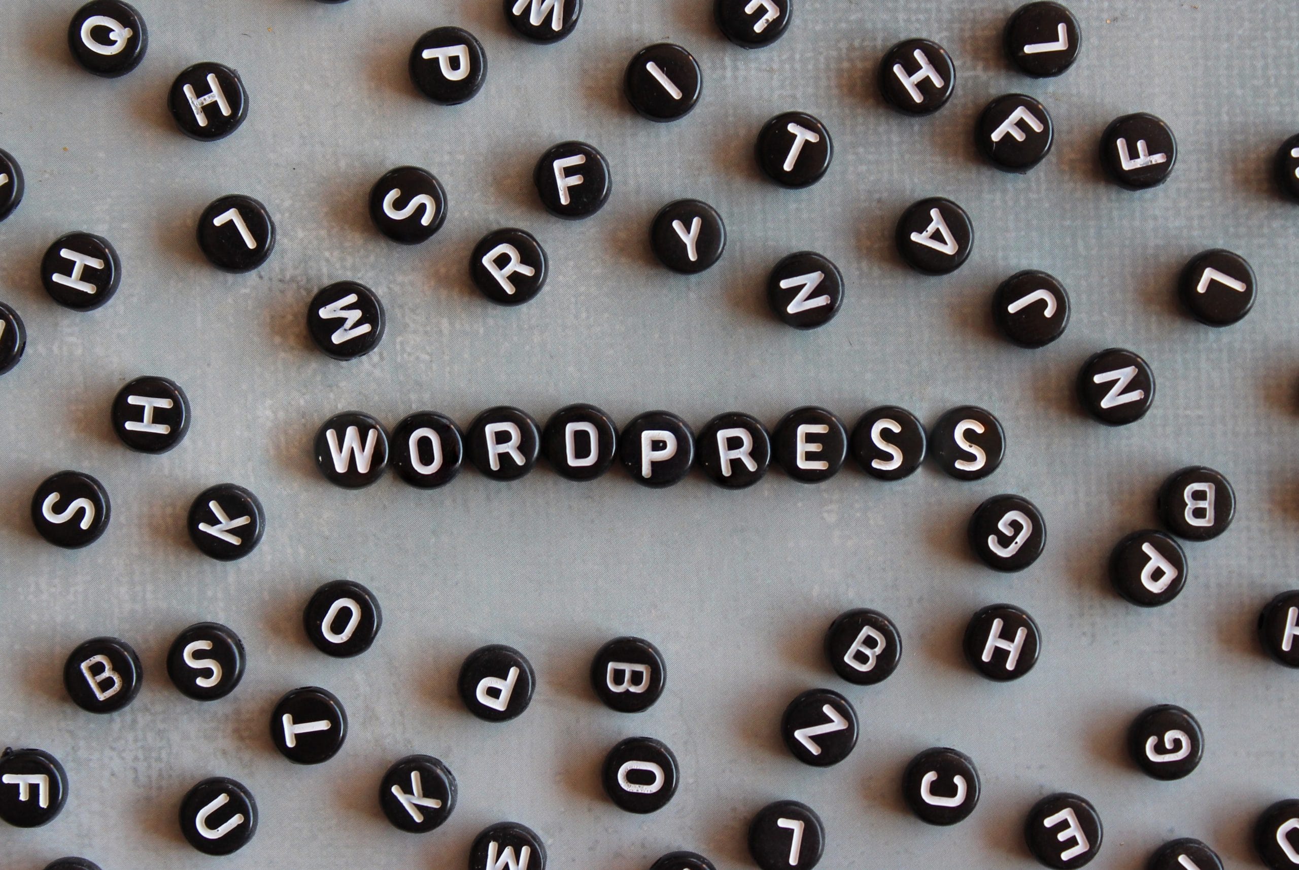 Alphabet beads with text KEYWORD on concrete floor | YZZY Agency